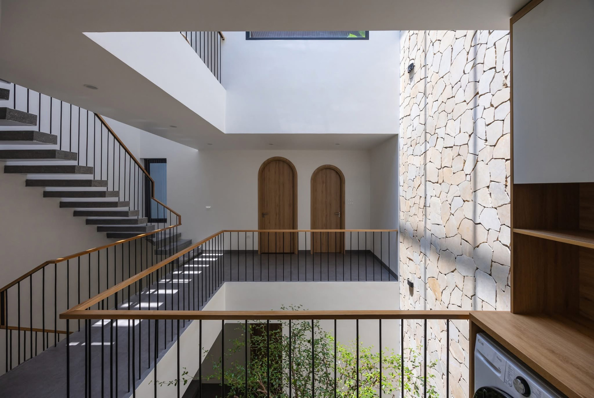 Stair and bridge landing with arched timber doors and stone wall