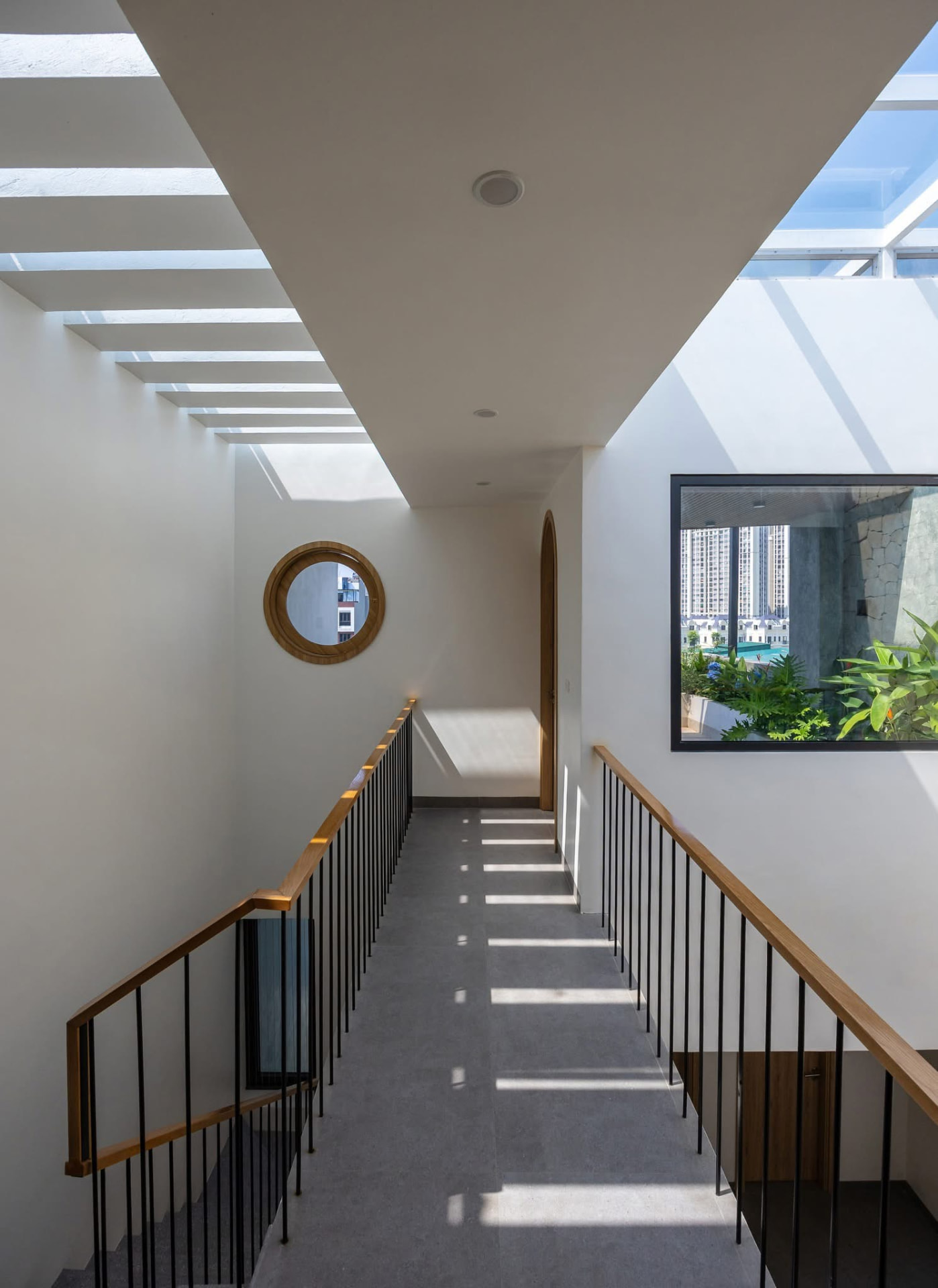 Bridge landing lit by slotted skylights with a garden window