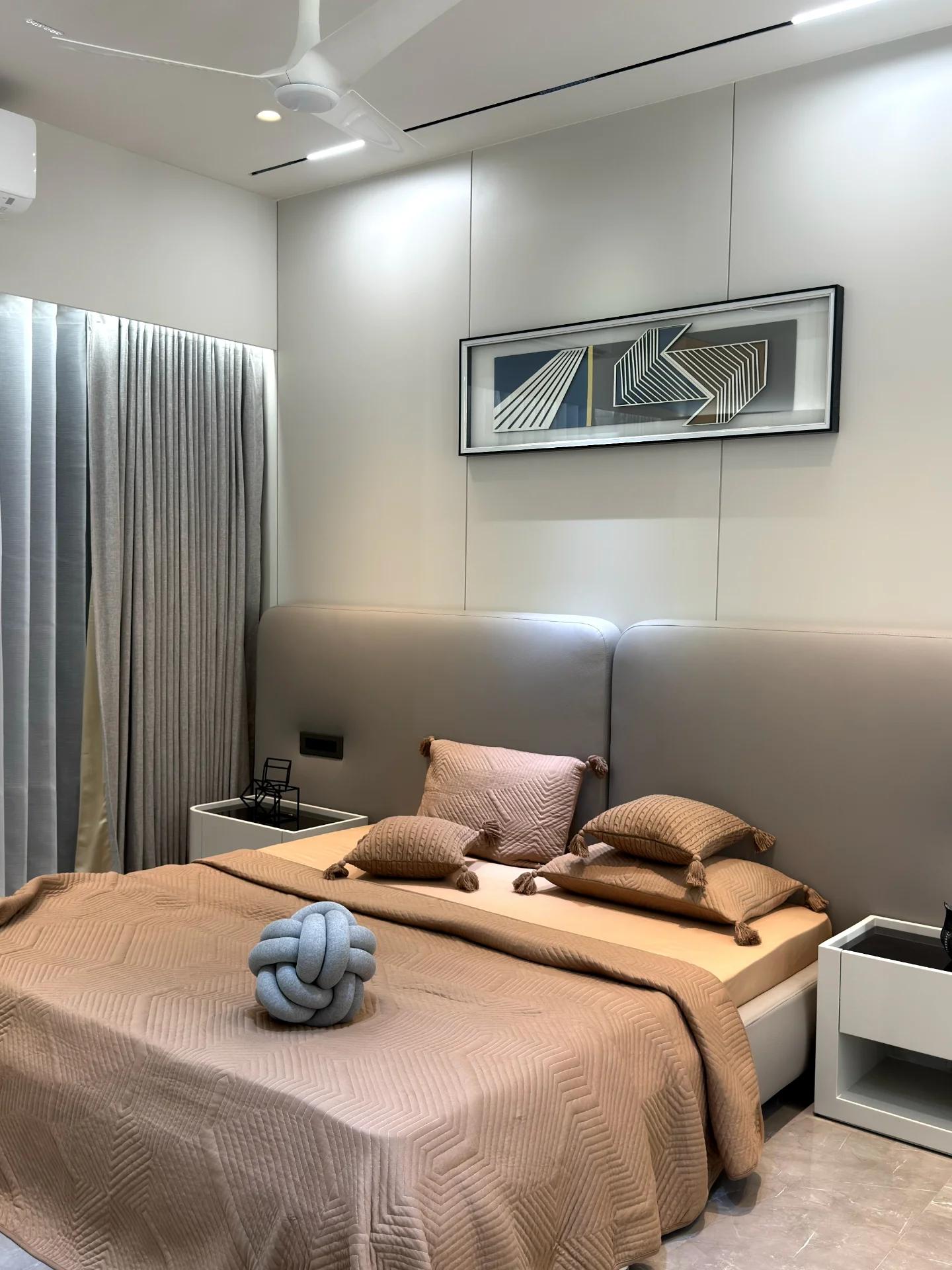 Guest bedroom with upholstered headboard and framed graphic artwork