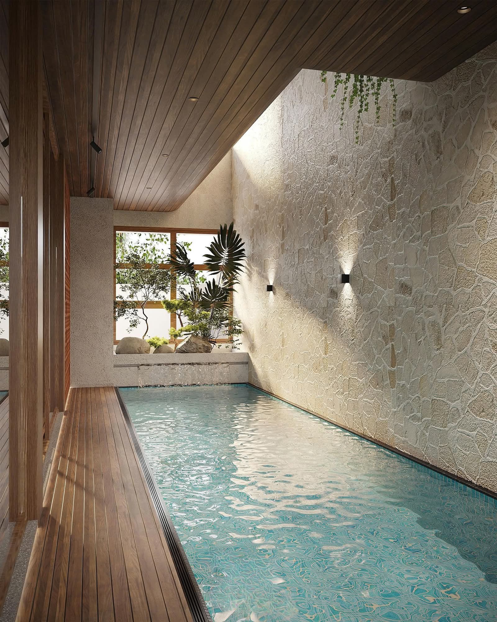 Lap pool beside a rough stone wall with a timber-lined ceiling