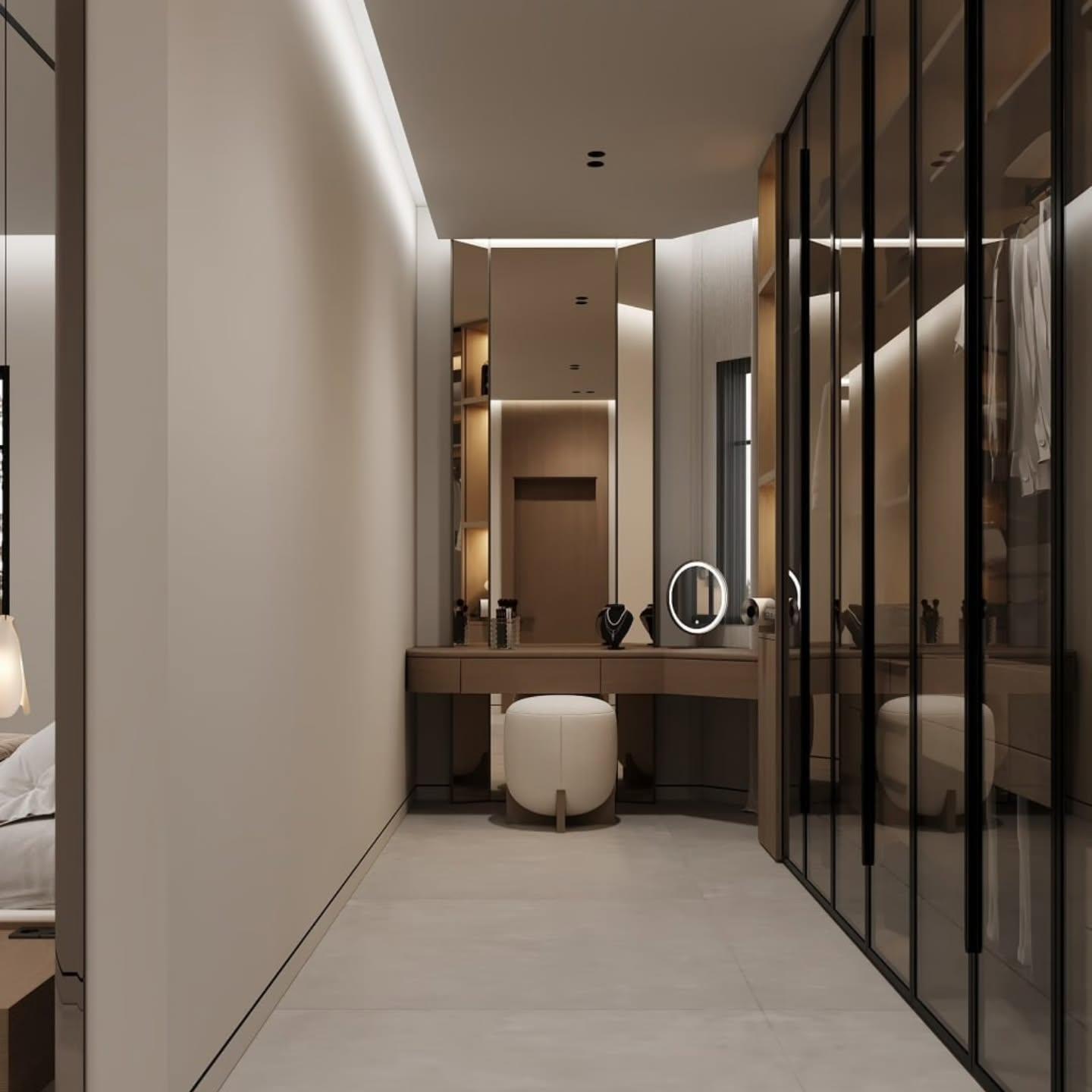 Walk-in dressing room with bronze glass wardrobes and a lit vanity