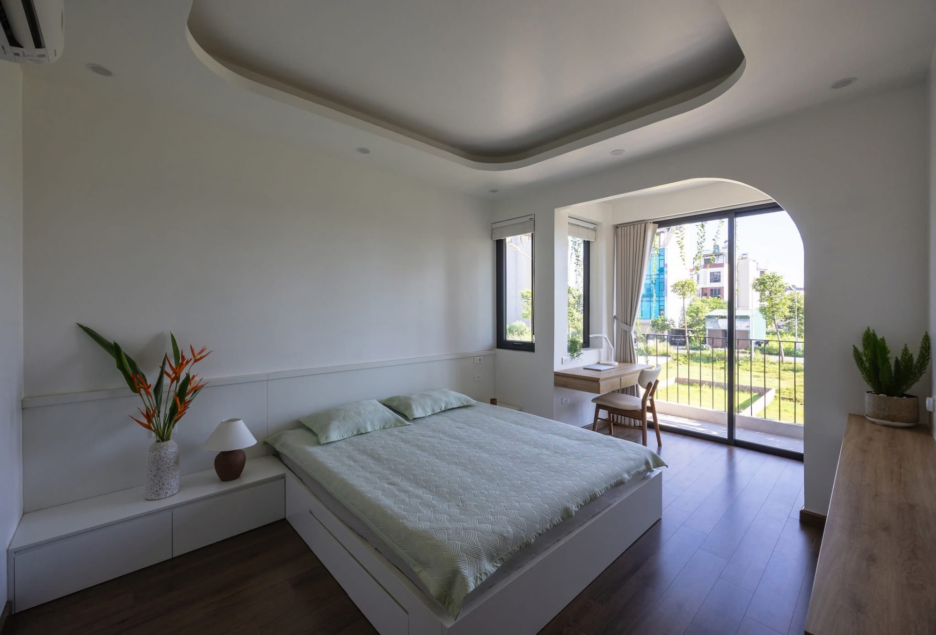 Bedroom opening to a balcony through an arched opening