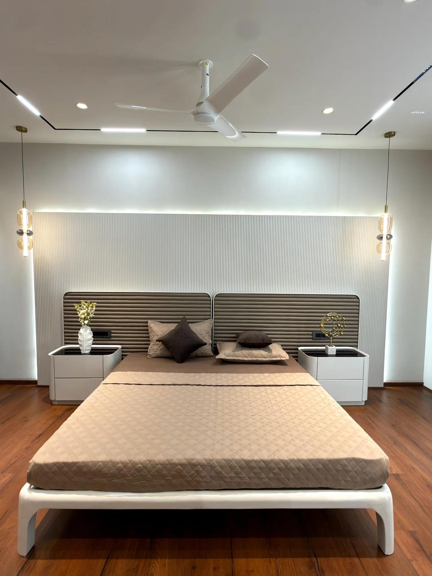 Master bedroom with ribbed leather headboard and paired glass pendants