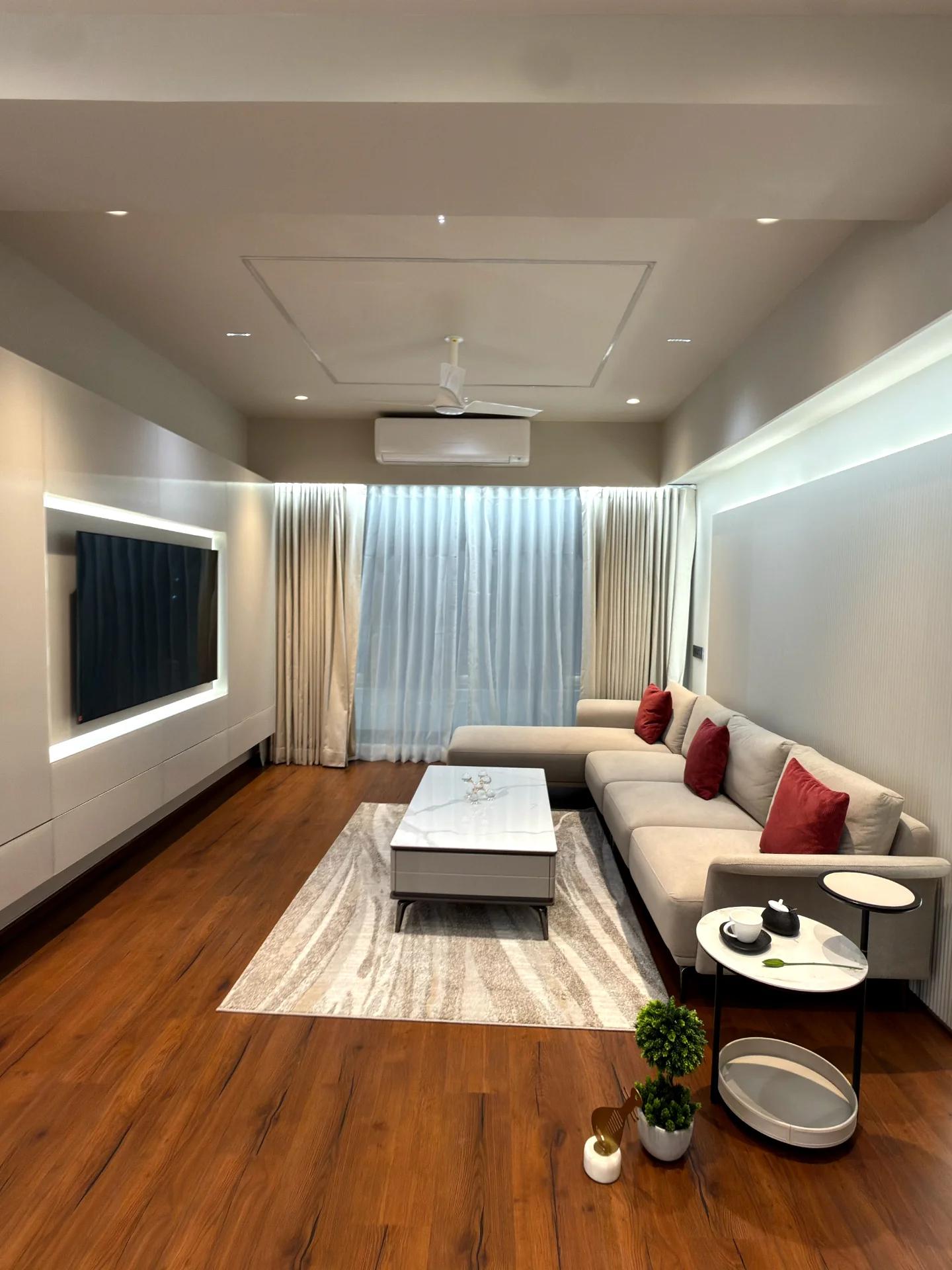 Family living room with backlit media wall and sheer layered drapery