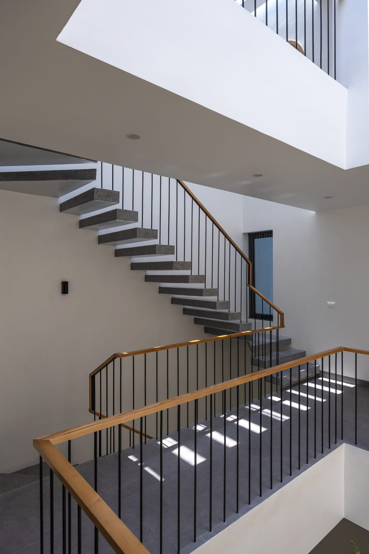 Stone stair flight turning beneath the skylight