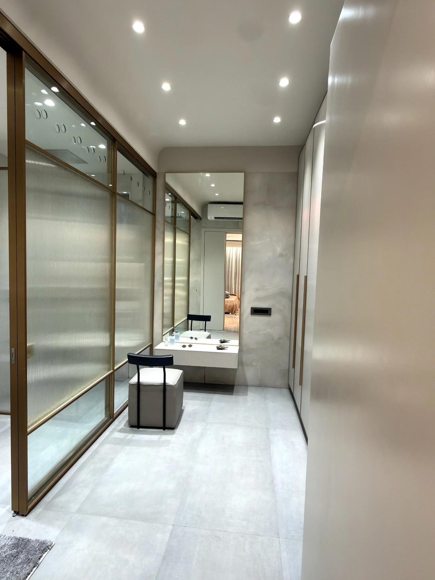 Dressing corridor with fluted glass doors, brass frames and vanity