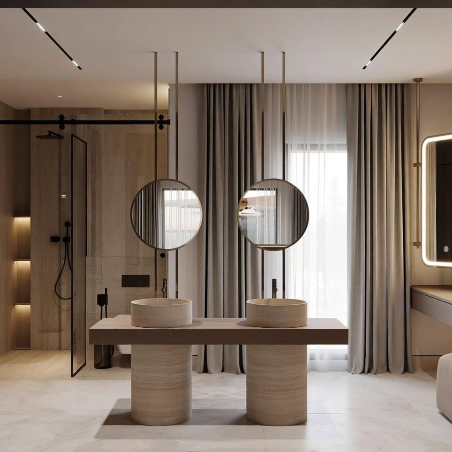 Vanity counter on cylindrical stone piers beside a glass shower