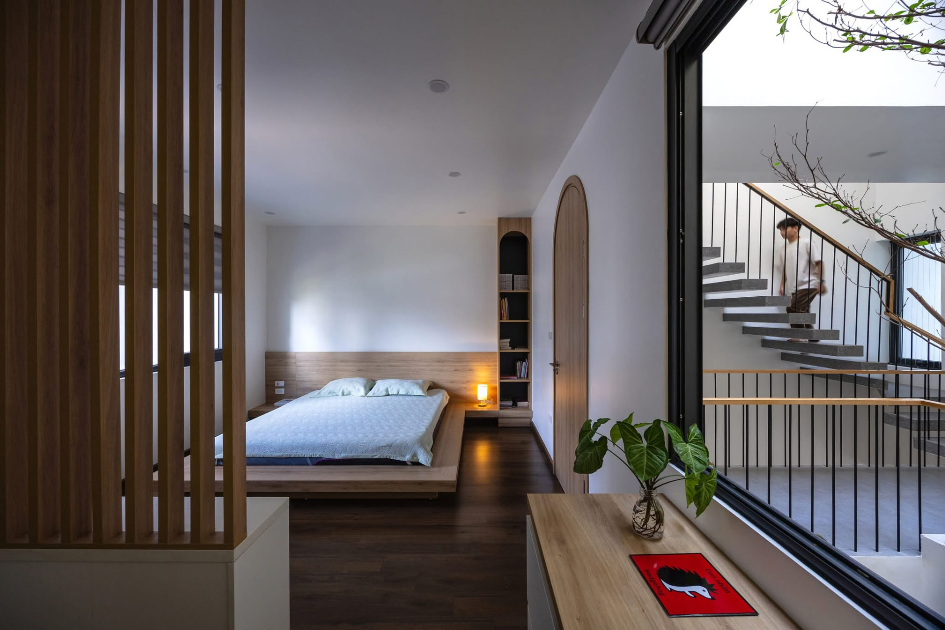 Bedroom looking through to the stair across a full-height window
