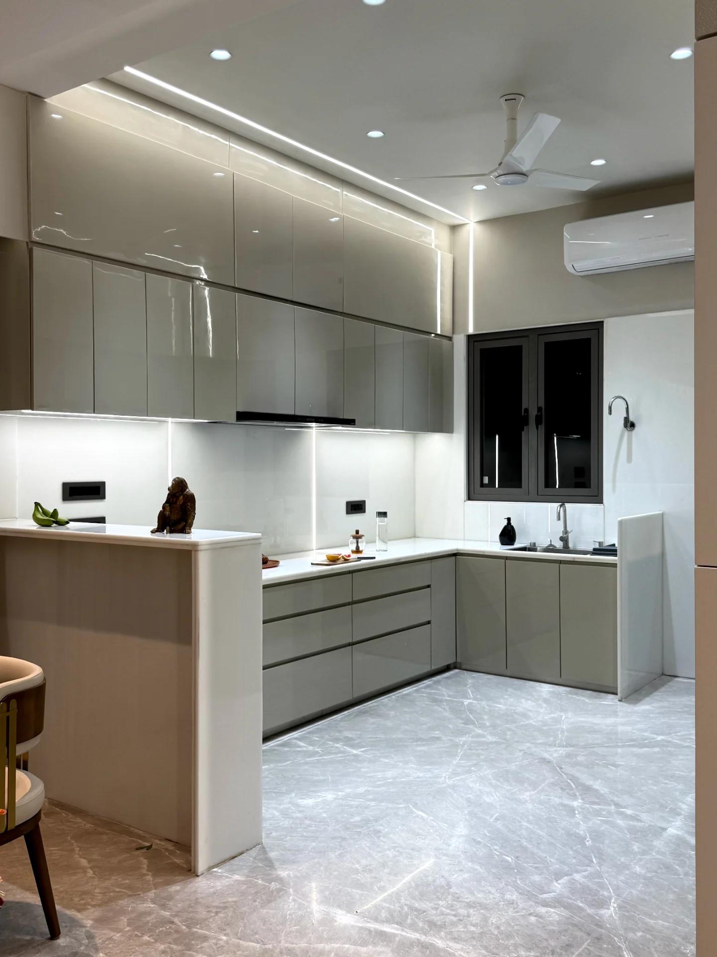 Kitchen in gloss cabinetry with quartz counter and under-cabinet lighting