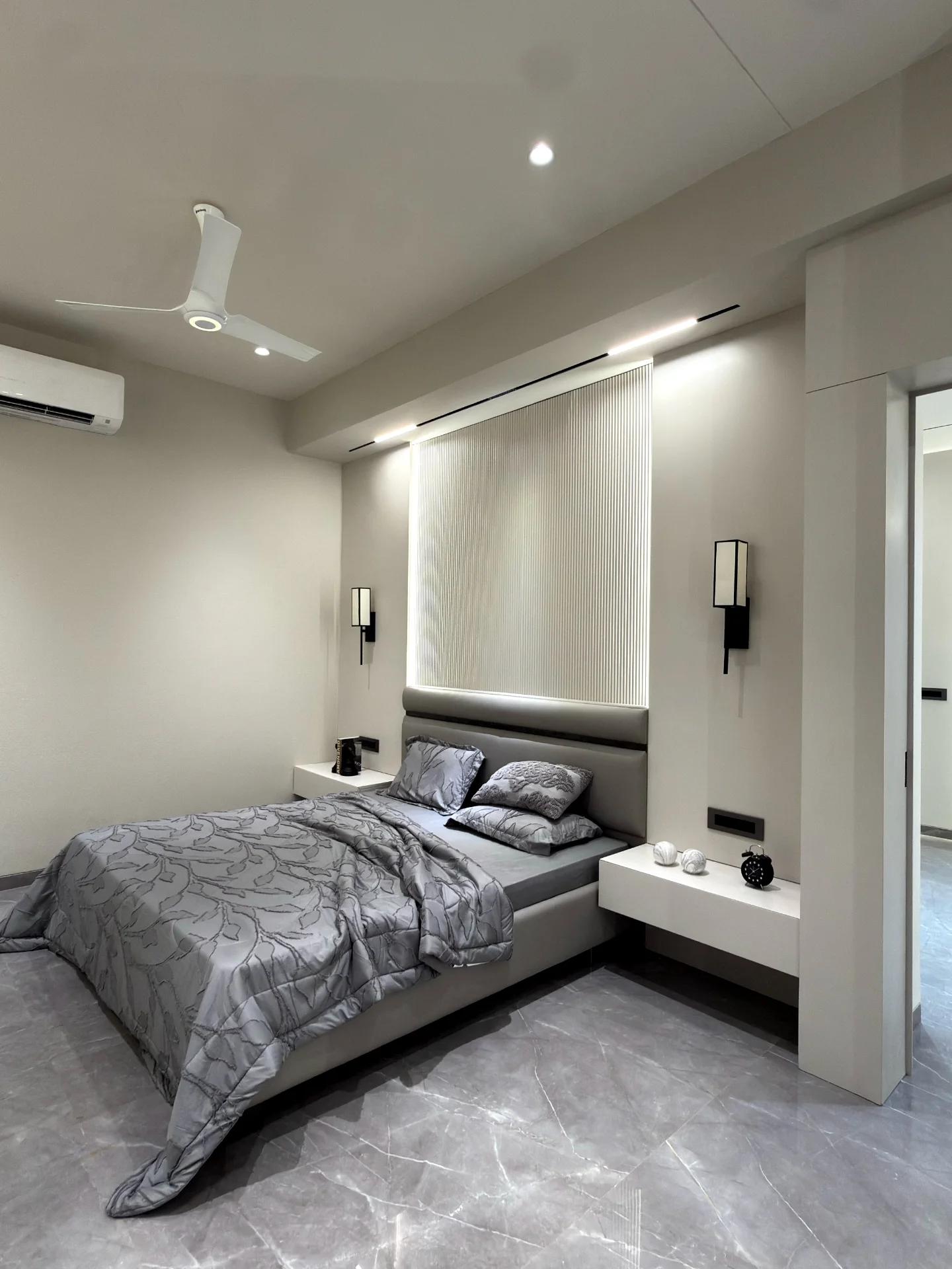 Bedroom with backlit fluted headboard panel and floating bedside shelves