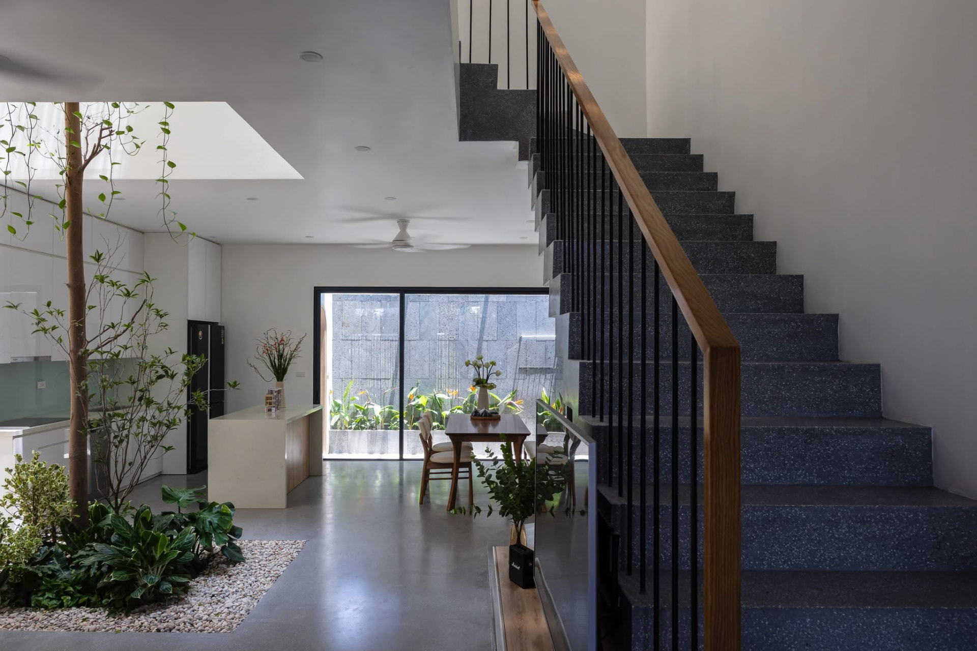 Stone stair with oak handrail beside the dining space